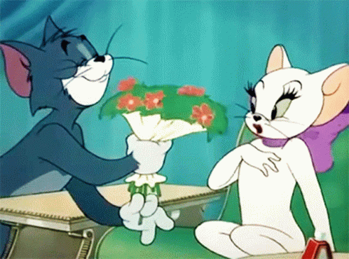A Cartoon Of Tom And Jerry Sitting At A Desk With Tom Holding A Bouquet Of Flowers GIF