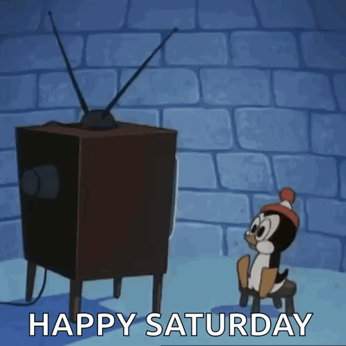 A Cartoon Penguin Is Sitting On A Stool In Front Of A Television With The Words Happy Saturday Written Below It . GIF