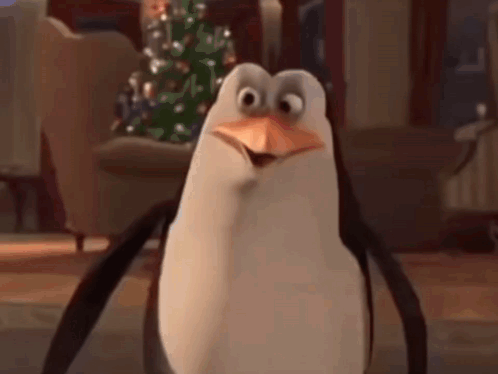 A Cartoon Penguin Is Standing In Front Of A Christmas Tree . GIF