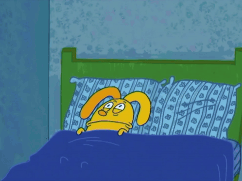a cartoon rabbit is laying in a bed with a blue blanket