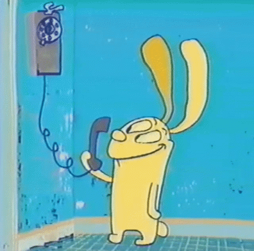 A Cartoon Rabbit Is Talking On A Pay Phone . GIF