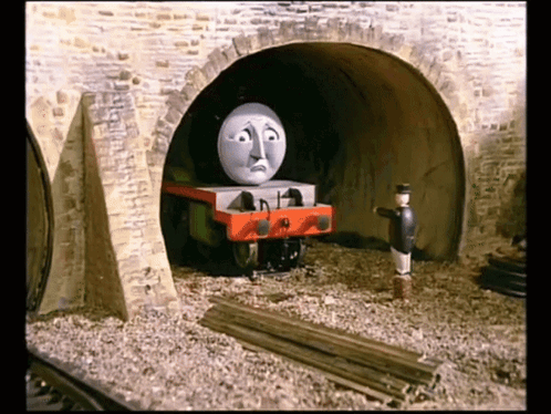 A Cartoon Train With A Sad Face Is Going Through A Tunnel GIF