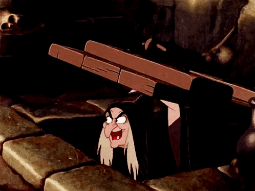 A Cartoon Witch Is Peeking Out Of A Hole In The Ground GIF
