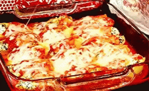 A Casserole Dish Filled With Cheese And Tomatoes GIF