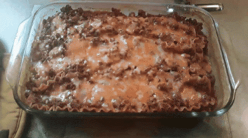 A Casserole Dish Filled With Lasagna And Cheese GIF