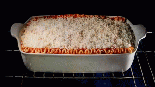 A Casserole Dish Filled With Macaroni And Cheese Is Being Cooked In An Oven GIF