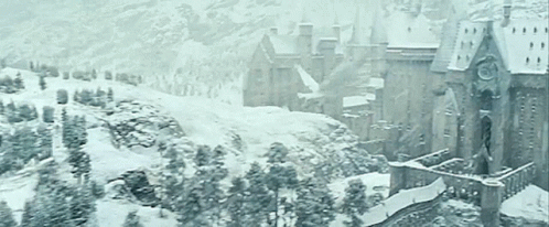 a castle is surrounded by snow covered trees and mountains