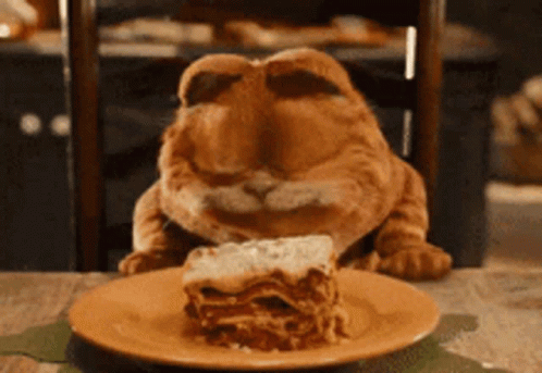 A Cat Is Eating A Slice Of Lasagna GIF