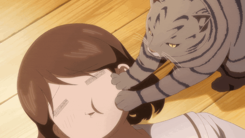 A Cat Is Petting A Woman 'S Ear While Laying On A Wooden Floor GIF
