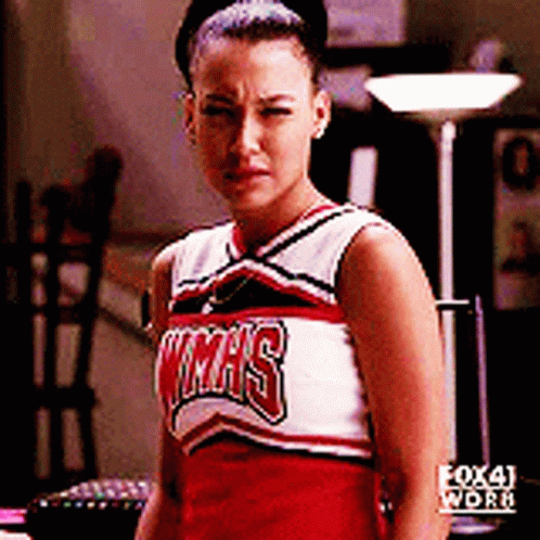 A Cheerleader Wearing A Texas Uniform Is Looking At The Camera GIF
