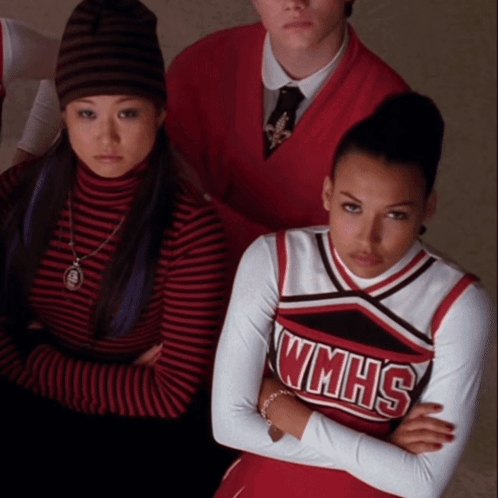 A Cheerleader Wearing A Wmhs Uniform Is Sitting With Her Arms Crossed GIF