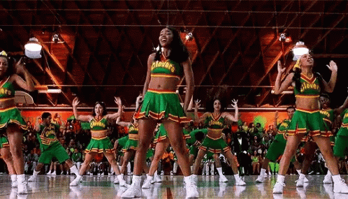A Cheerleading Team Is Performing On A Basketball Court In Front Of A Crowd . GIF