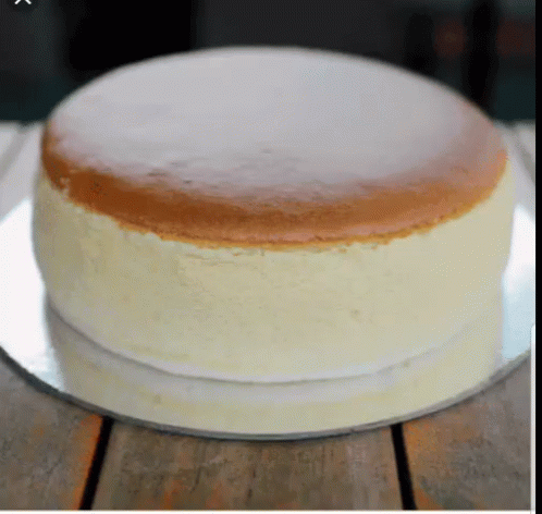 A Cheesecake Is Sitting On A Silver Plate On A Table GIF