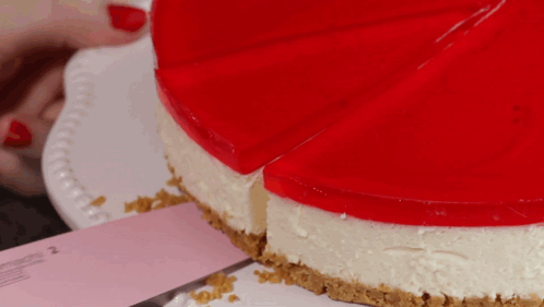 A Cheesecake With A Slice Taken Out Of It On A White Plate GIF