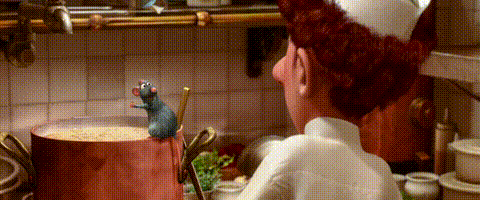 A Chef Is Standing In A Kitchen Looking At A Pot Of Soup With A Rat In It . GIF