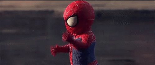A Child Dressed In A Spiderman Costume Is Walking Down A Street GIF