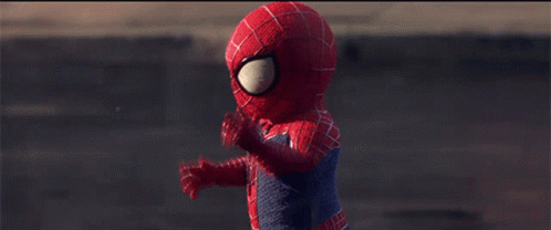 A Child Dressed In A Spiderman Costume Is Walking Down A Street GIF