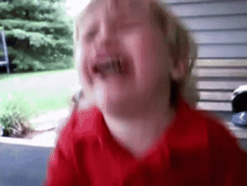 A Child In A Red Shirt Is Crying With His Mouth Open GIF