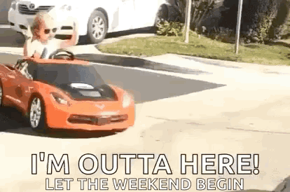 A Child Is Driving A Toy Car Down A Street . GIF
