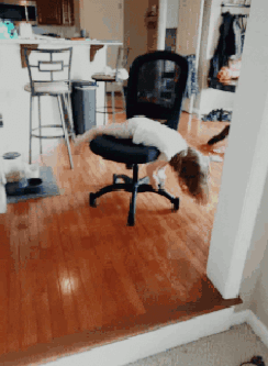 A Child Is Laying On A Chair In A Room GIF