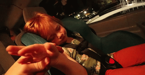A Child Is Sleeping In A Car Seat With A Hand Reaching Out GIF