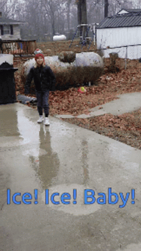A Child Is Walking Down A Wet Sidewalk With The Words Ice Ice Baby GIF