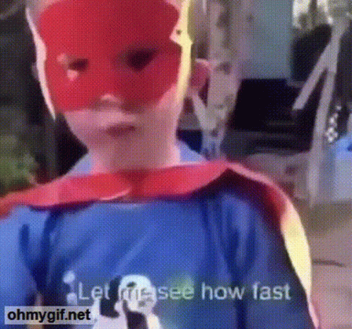 A Child Is Wearing A Red Mask And A Cape And Says Let Me See How Fast GIF