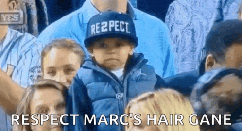 A Child Wearing A Hat That Says Respect Is Sitting In A Crowd Of People . GIF