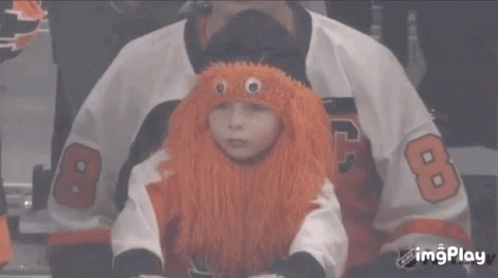 A Child Wearing An Orange Wig And A Jersey With The Number 8 GIF