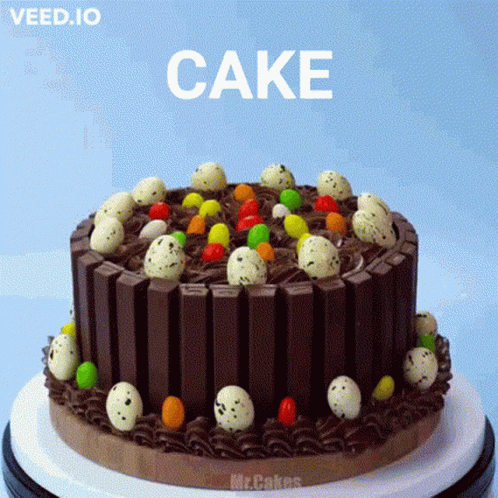 A Chocolate Cake With Easter Eggs On Top And The Word Cake On The Bottom GIF