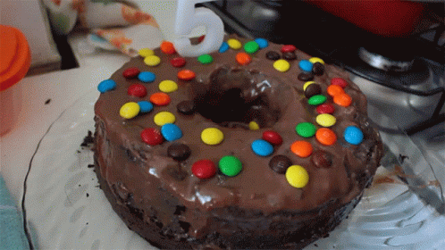 A Chocolate Cake With M & M 'S And A Number 5 On Top GIF