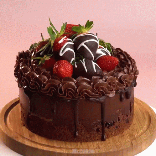a chocolate cake with strawberries on top is on a cutting board