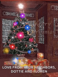 A Christmas Tree In A Living Room With Gifts Underneath It GIF