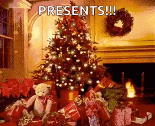 A Christmas Tree Is Surrounded By Presents And A Teddy Bear GIF