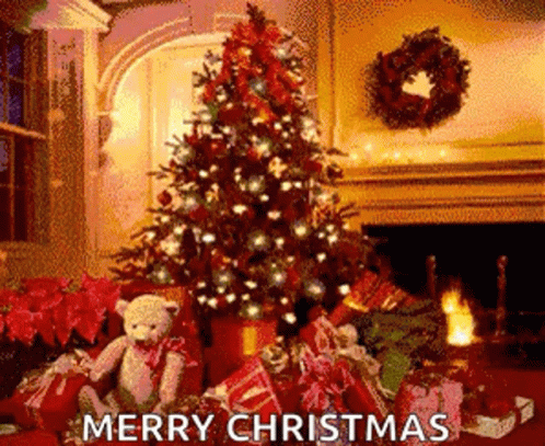 A Christmas Tree With Gifts Underneath It And A Teddy Bear Sitting Underneath It . GIF
