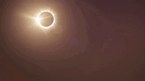 A City Skyline With A Partial Eclipse Of The Sun GIF