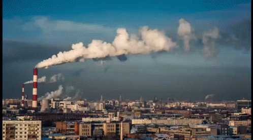 A Cityscape With Smoke Coming Out Of A Factory GIF