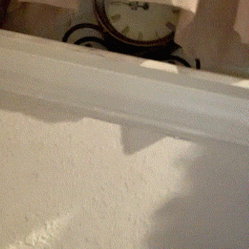 A Clock On A White Wall Shows The Time As Almost 5:00 GIF