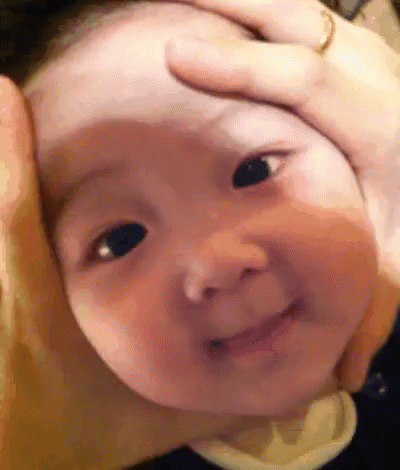 A Close Up Of A Baby 'S Face With A Person Holding It . GIF