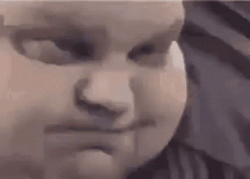 A Close Up Of A Baby 'S Face With A Serious Look On His Face . GIF