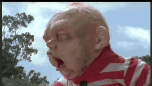 A Close Up Of A Baby 'S Face With A Striped Shirt On GIF