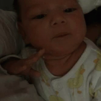 A Close Up Of A Baby 'S Face With A White Shirt On GIF