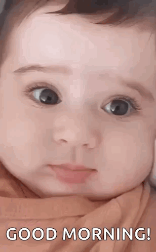 A Close Up Of A Baby 'S Face With The Words `` Good Morning '' Written Above It . GIF