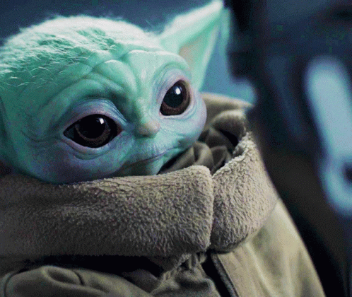 A Close Up Of A Baby Yoda In A Jacket GIF