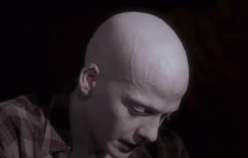 A Close Up Of A Bald Man 'S Head With A Plaid Shirt On GIF