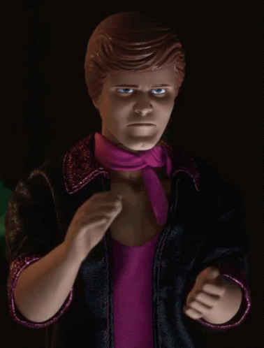 A Close Up Of A Barbie Doll With A Pink Scarf Around His Neck GIF