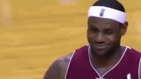 a close up of a basketball player wearing a headband and smiling on a court .