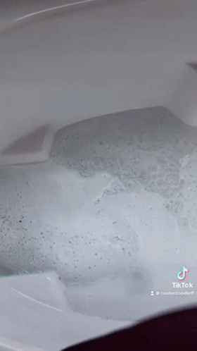 A Close Up Of A Bathtub Filled With Bubbles And Water . GIF