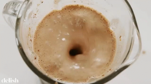 A Close Up Of A Blender Filled With A Brown Liquid GIF