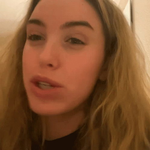 A Close Up Of A Blonde Woman 'S Face With A Black Shirt On GIF